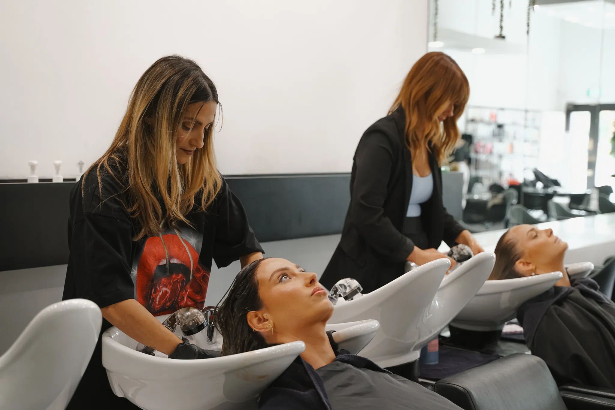 Two clients receiving an in-salon hair treatment and basin wash at Salon Ayre, boutique hair salon Mentone VIC