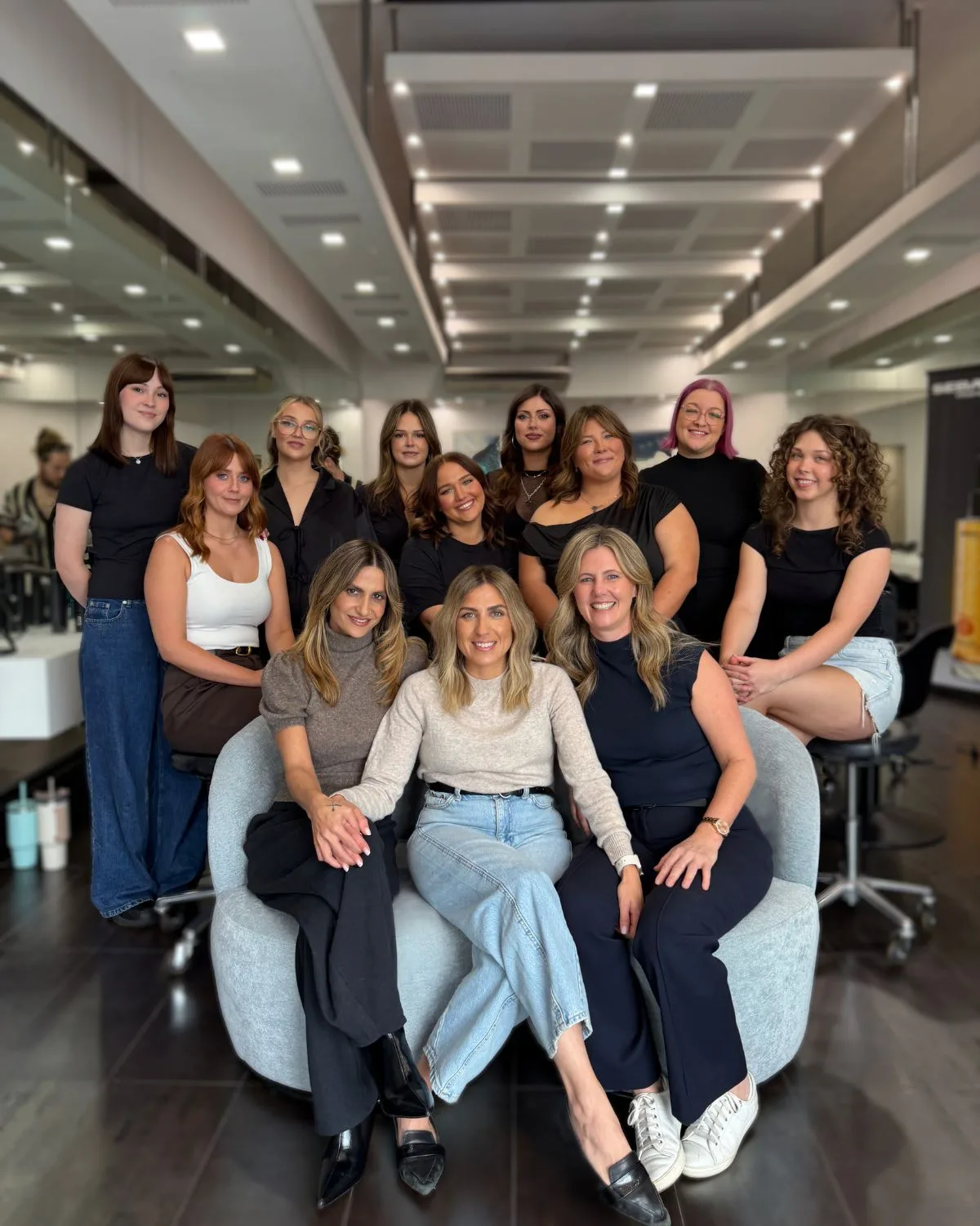 The Salon Ayre team, co-founders Emily and Sarah seated with their stylists, colourists, and apprentices in the Mentone salon