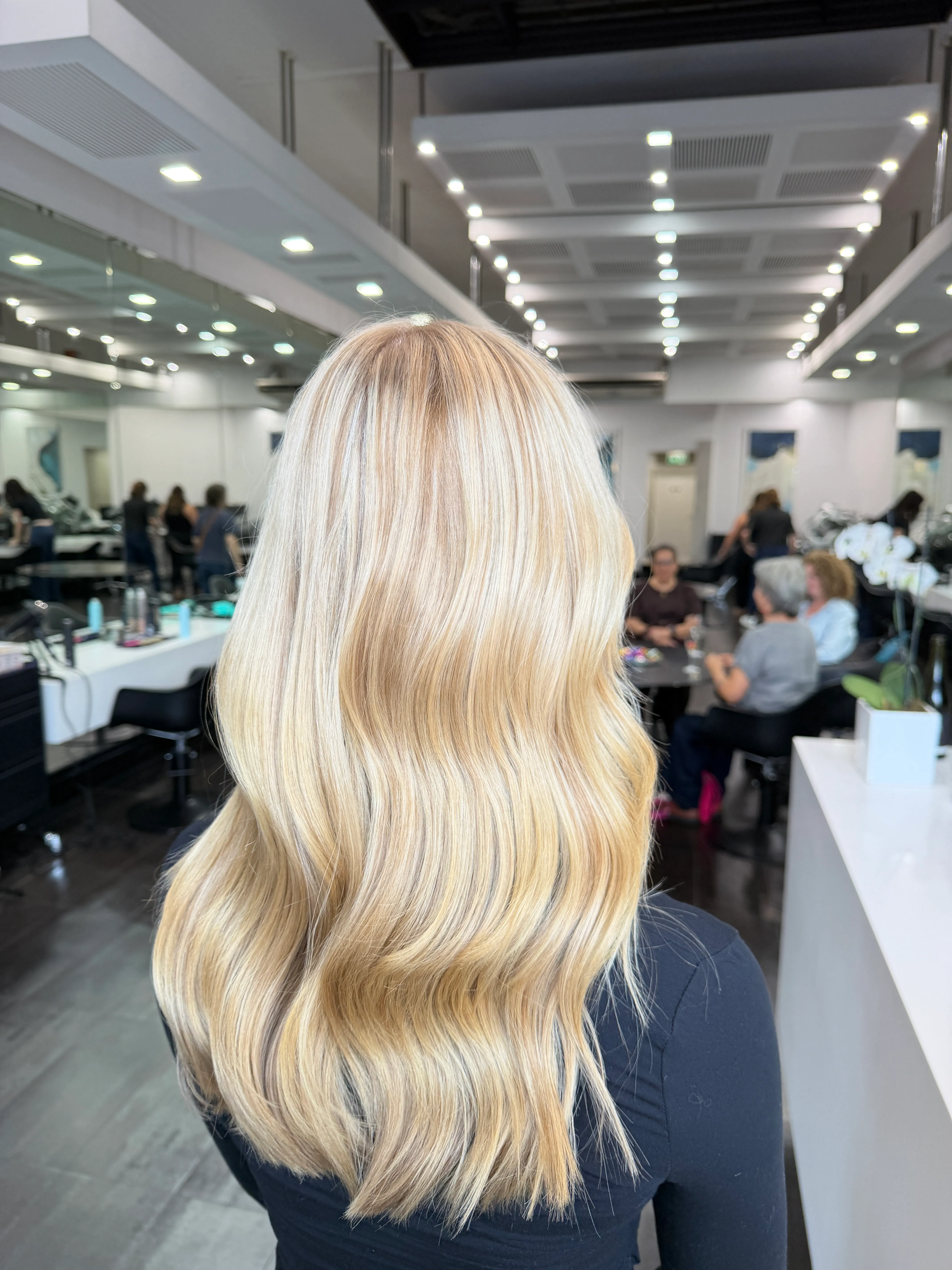 Seamless blonde balayage with soft waves at Salon Ayre Mentone